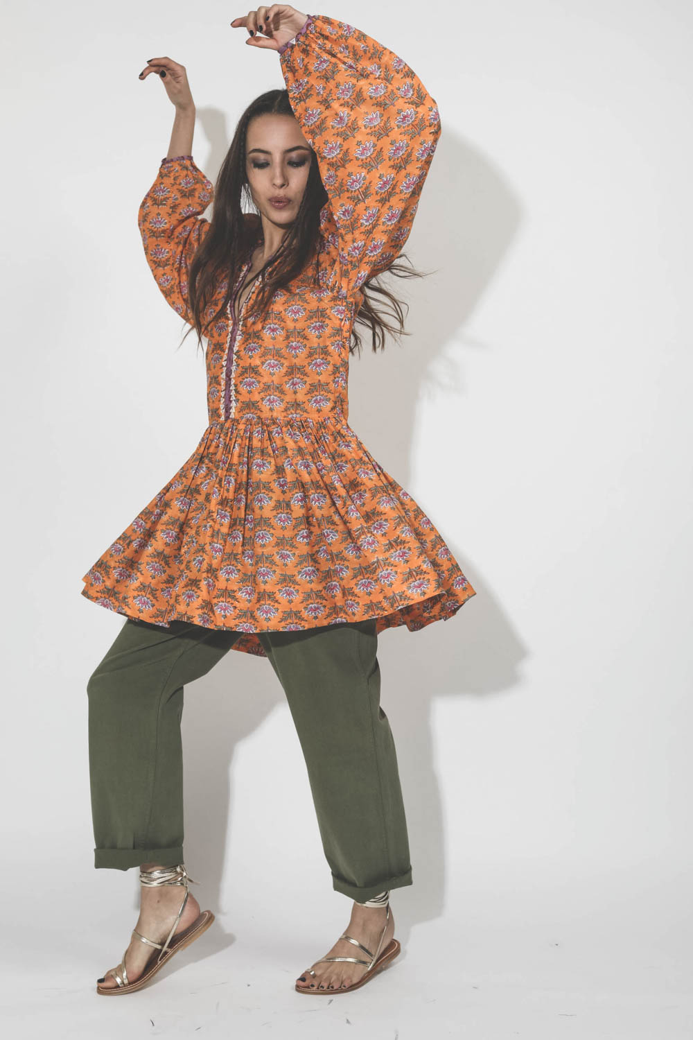 Robe courte manches longues en coton imprimé fleurs orange Sula Alix of Bohemain. Porté sur un pantalon kaki. 