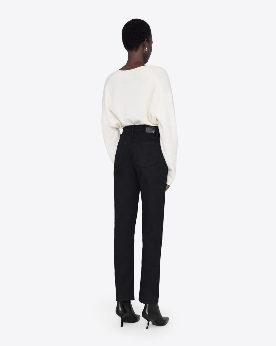 Jeans taille haute Bruno Anine Bing en toile noire. Porté de dos avec un pull en cachemire écru.