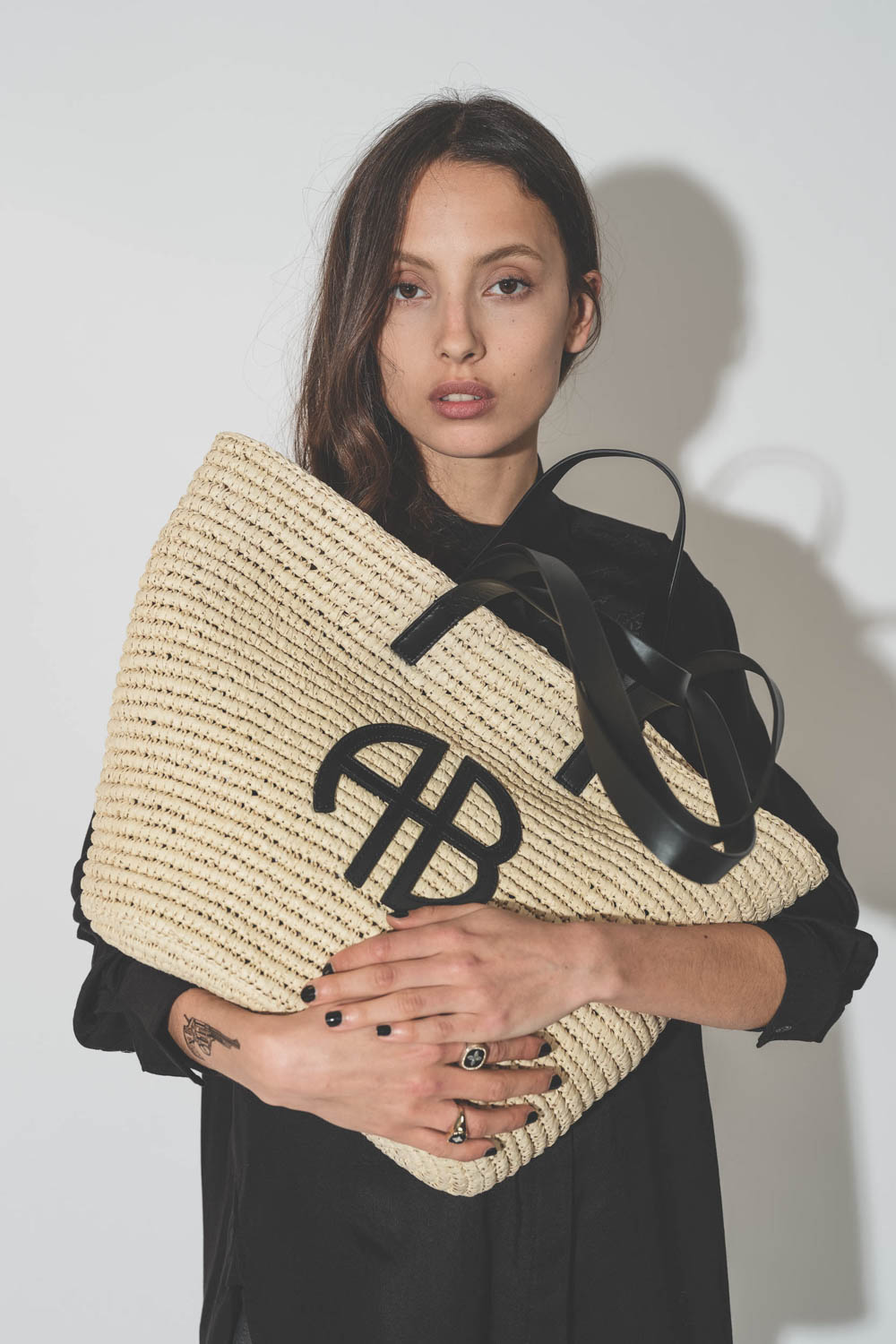 Panier en osier naturel finitions cuir noir Palermo Anine Bing. Détail du logo en cuir noir AB. 