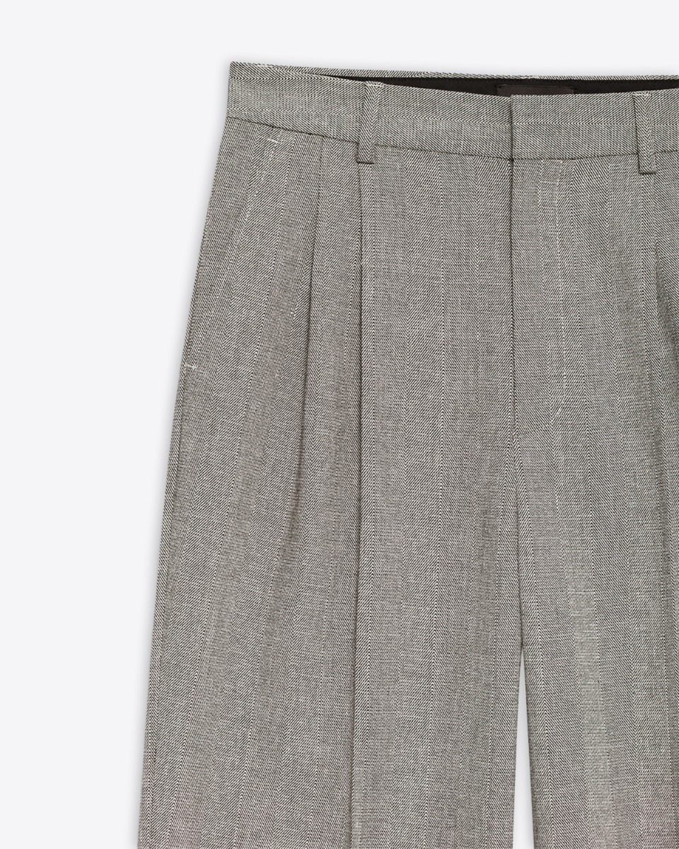 Pantalon Belen Anine Bing ivoire et noir à chevrons. Détail de la matière, de la poche italienne et des plis devant. 