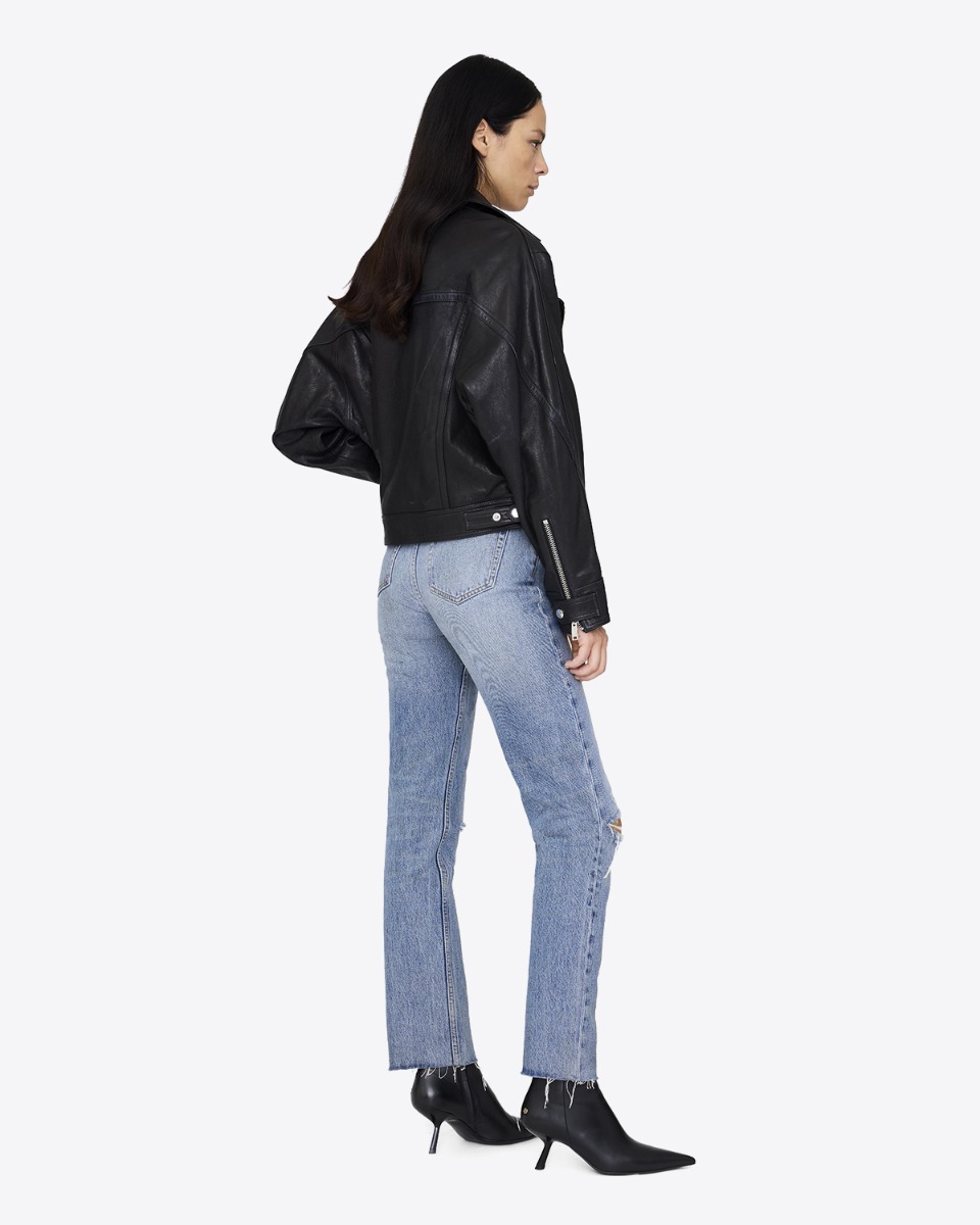 Perfecto Julie Anine Bing en cuir noir, porté de face avec un jean skinny bleu ciel.