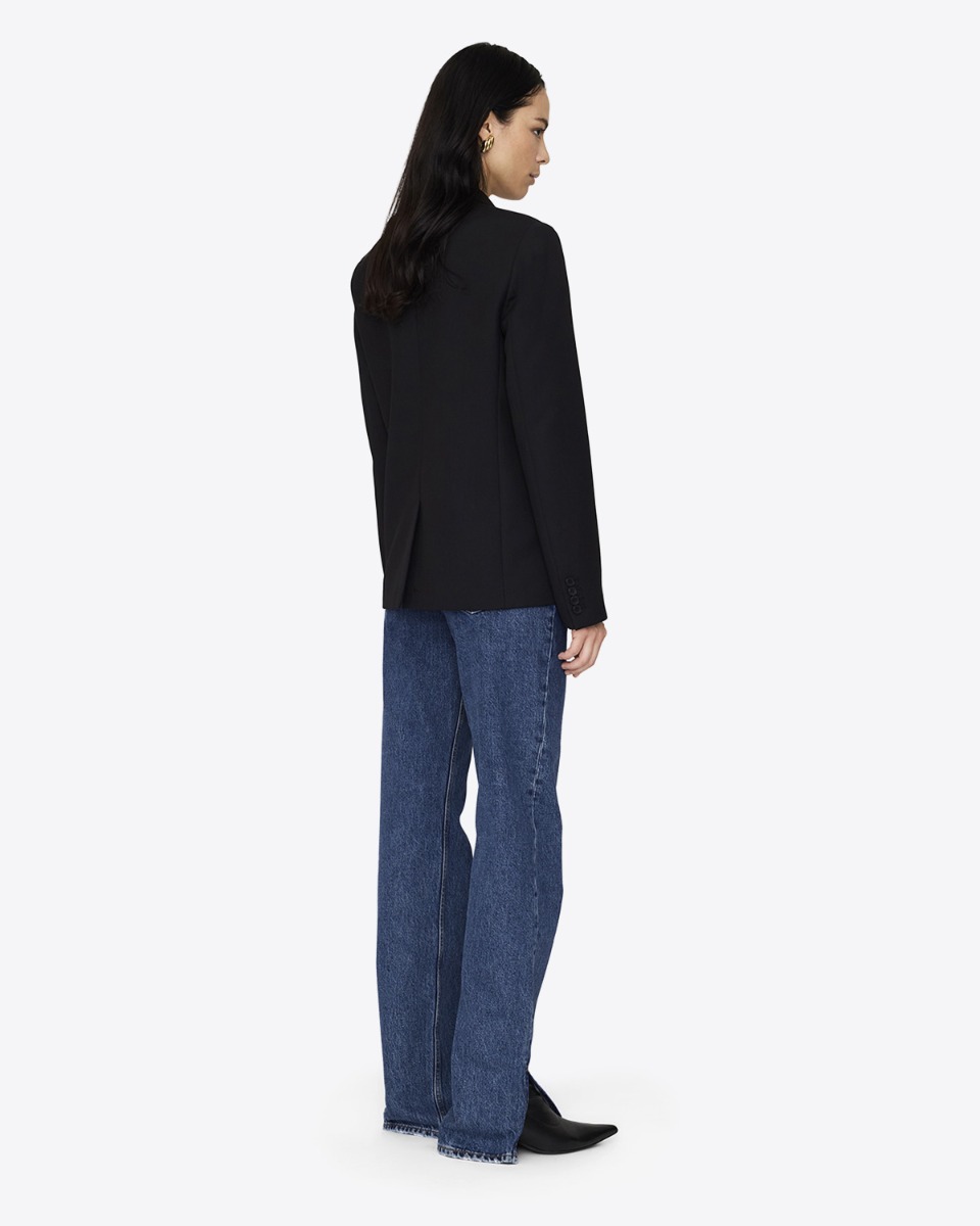 Veste croisée Evalyn Anine Bing noire portée de dos avec un jean bleu.