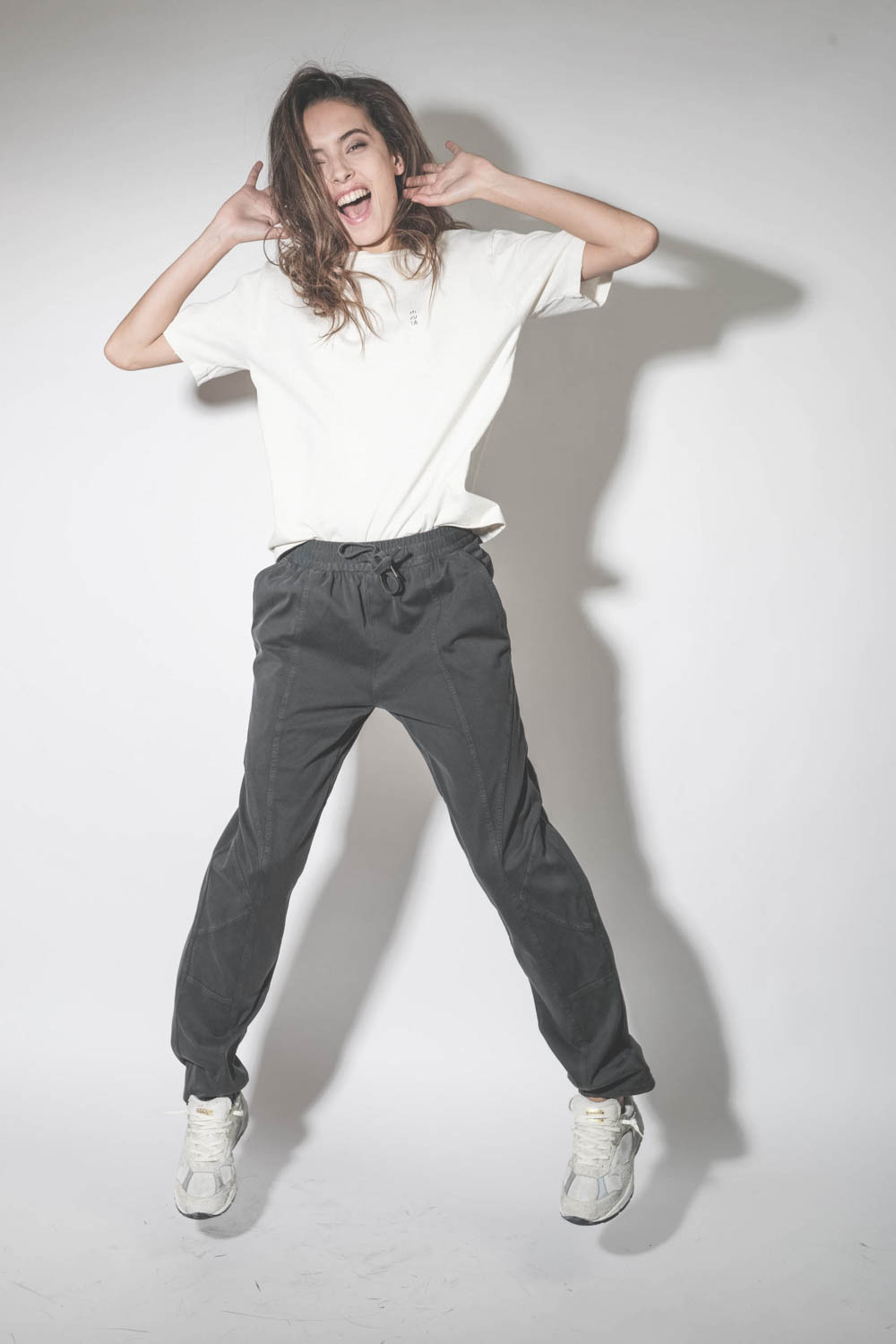 Baskets Running Dad blanche étoile en cuir lisse blanc Golden Goose femme.  Porté de face en sautant.