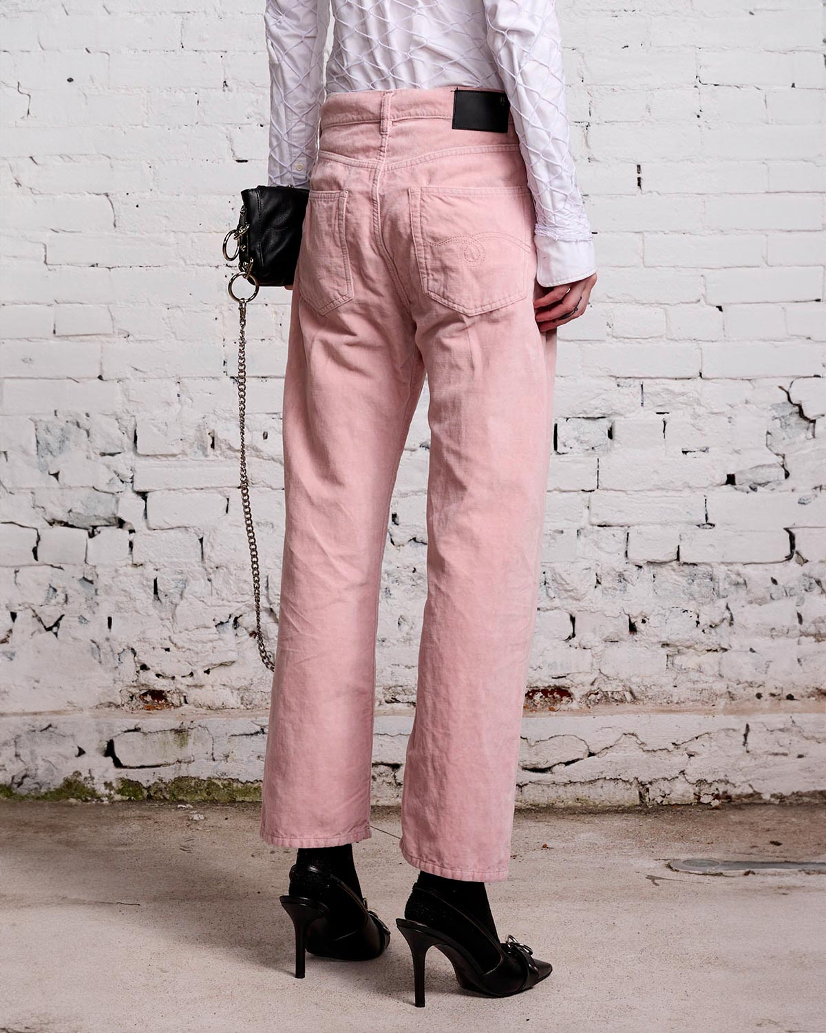 Jean Boyfriend en velours lisse rose r13. Porté avec une pochette et des escarpins. 
