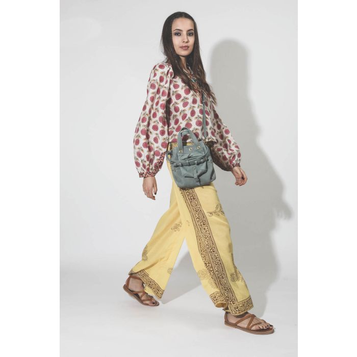Pantalon en voile de coton imprimé jaune Alix of Bohemian. Porté avec une blouse à fleurs.