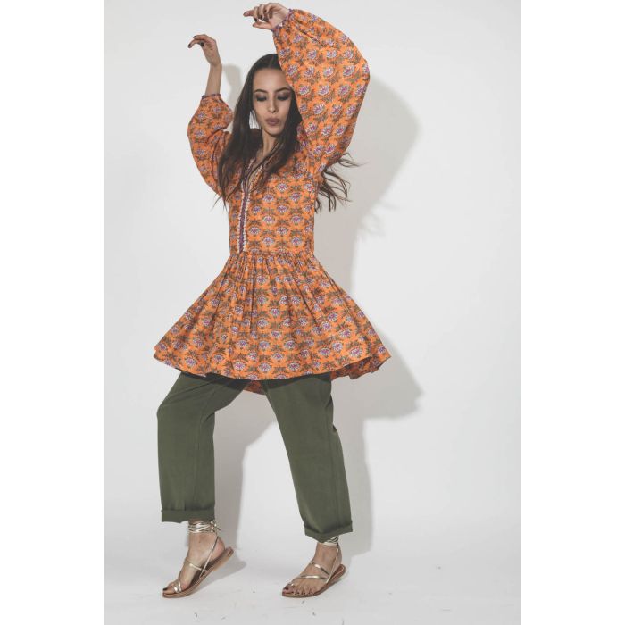 Robe courte manches longues en coton imprimé fleurs orange Sula Alix of Bohemain. Porté sur un pantalon kaki. 