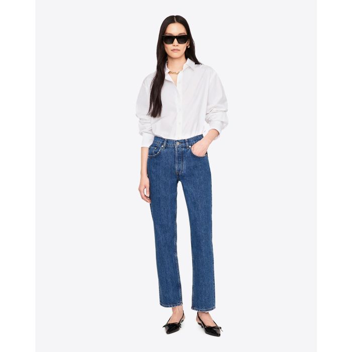 Chemise manches longues classique en popeline de coton blanche Essie Anine Bing. Face. Porté avec un jean bleu.