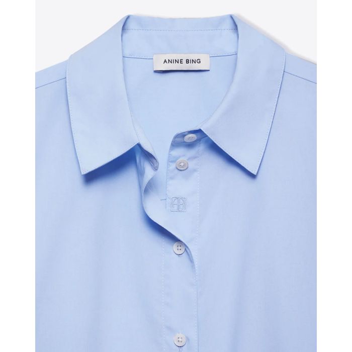 Chemise classique en popeline de coton bleu ciel Essie Anine Bing. Détail du col avec une broderie AB ton sur ton sur la patte de boutonnage. 