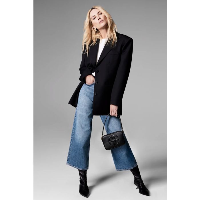 Jean large taille haute Rick Anine Bing en denim bleu délavé. Porté avec une veste noire par Erin Wasson.