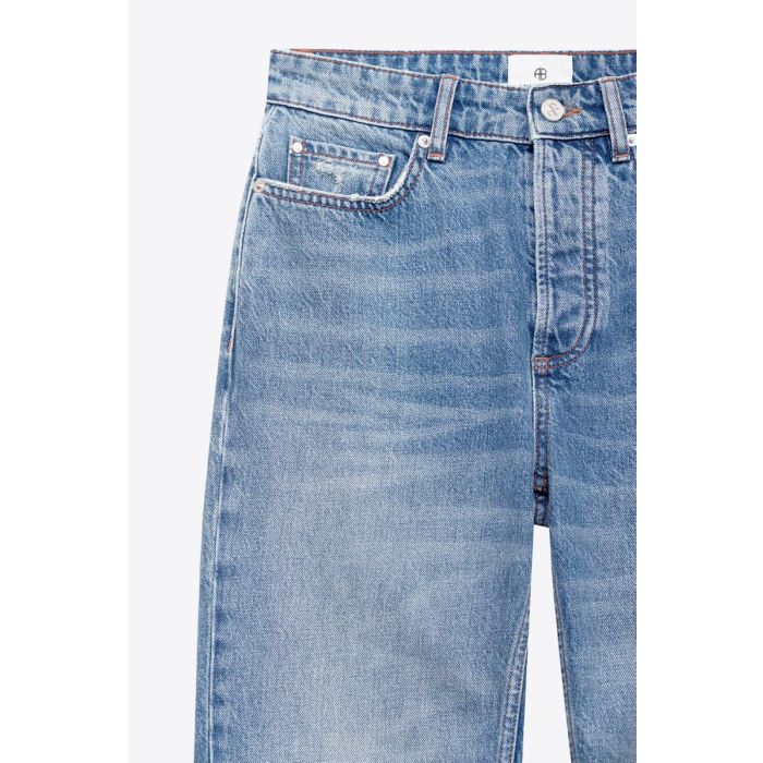 Jean taille haute slim Bruno Anine Bing en denim régénératif bleu déchiré aux genoux. Détail de la toile denim.