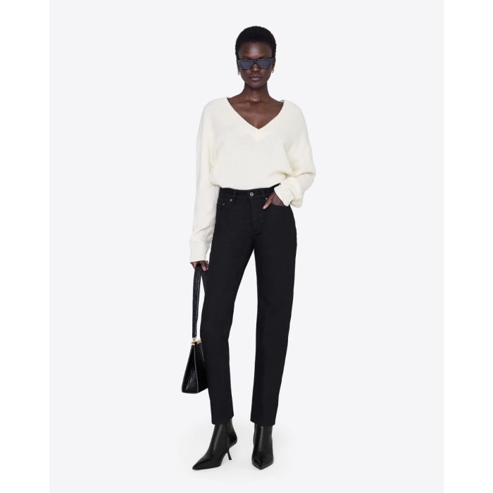 Jeans taille haute Bruno Anine Bing en toile noire, porté de face avec un pull en cachemire écru.