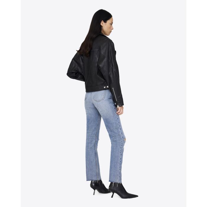 Perfecto Julie Anine Bing en cuir noir, porté de face avec un jean skinny bleu ciel.