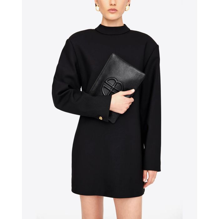Pochette rectangulaire Lili en cuir noir Anine Bing. Portée à la main avec une robe noire. 