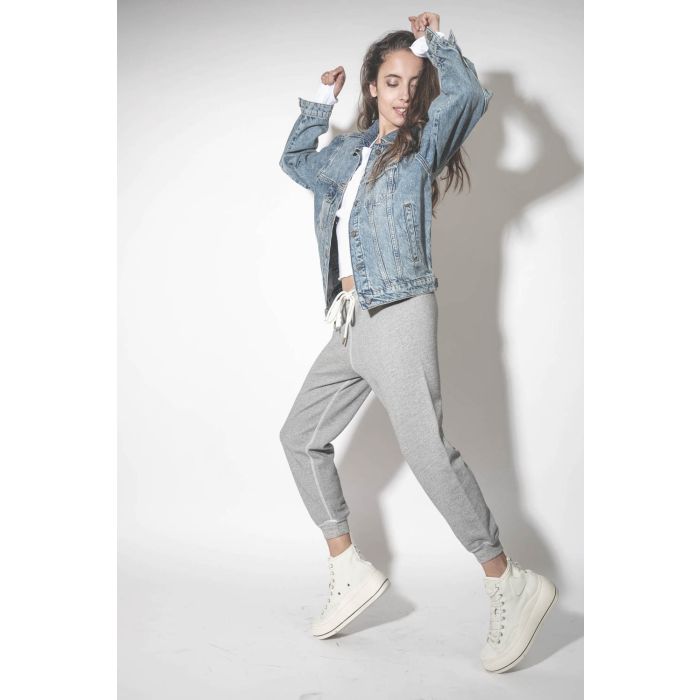 Blouson en jean bleu délavé Vintage Indigo Rory Anine Bing.Porté avec un bas de jogging gris chiné.