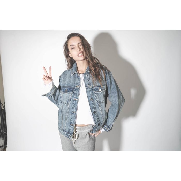 Blouson en jean bleu délavé Vintage Indigo Rory Anine Bing. Porté avec un tee-shirt manches longues blanc.