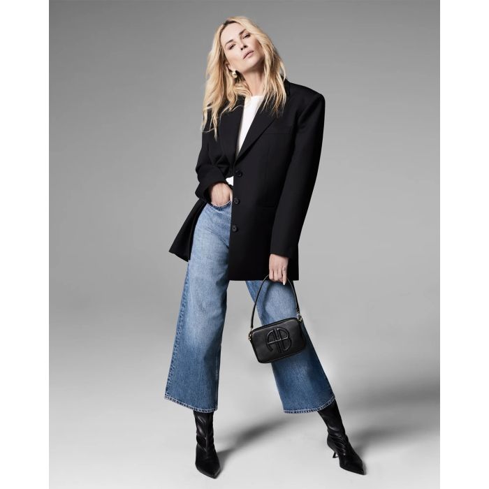 Petit sac en cuir noir porté bandoulière ou main Lili Anine Bing. Porté à la main par Erin Wasson.