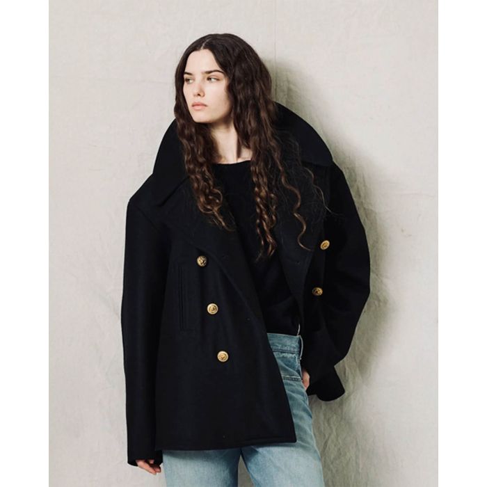 Caban oversize en drap de laine noir boutons gravés dorés Denimist. Porté ouvert col relevé.