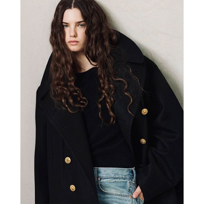 Caban oversize en drap de laine noir boutons gravés dorés Denimist. Porté avec un pull noir.