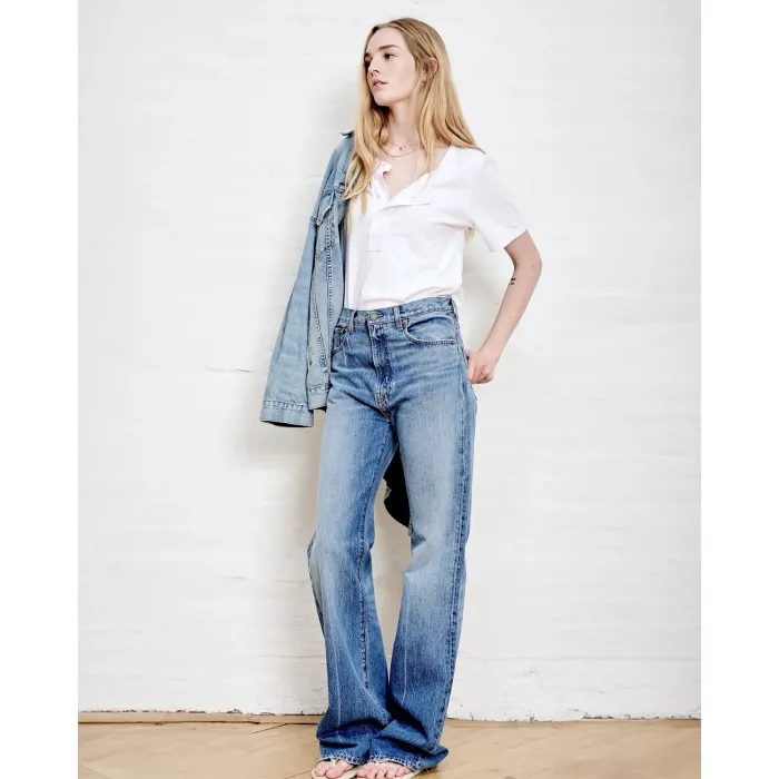 Jean taille haute évasé délavage Blake bleu ciel Dena Denimist. Porté avec un tee-shirt blanc col tunisien.
