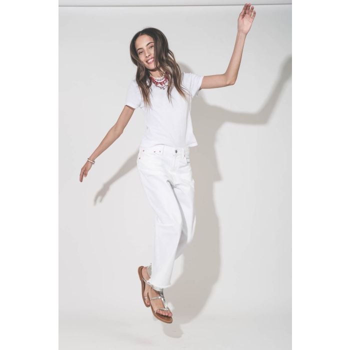 Jean large taille basse en toile blanche lavée Georgia Denimist. Porté de profil avec un tee-shirt Little blanc The Great et des sandales Caravelle en cuir argent K.Jacques Saint-Tropez. Bijoux Isabel Marant.