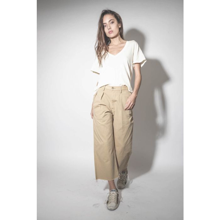 Pantalon large à pinces en toile de coton beige Chino Denimist. Porté avec des sneakers léopard.