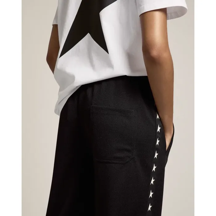 Pantalon de jogging noir avec étoiles blanches le long de la jambe Golden Goose. Porté de dos.
