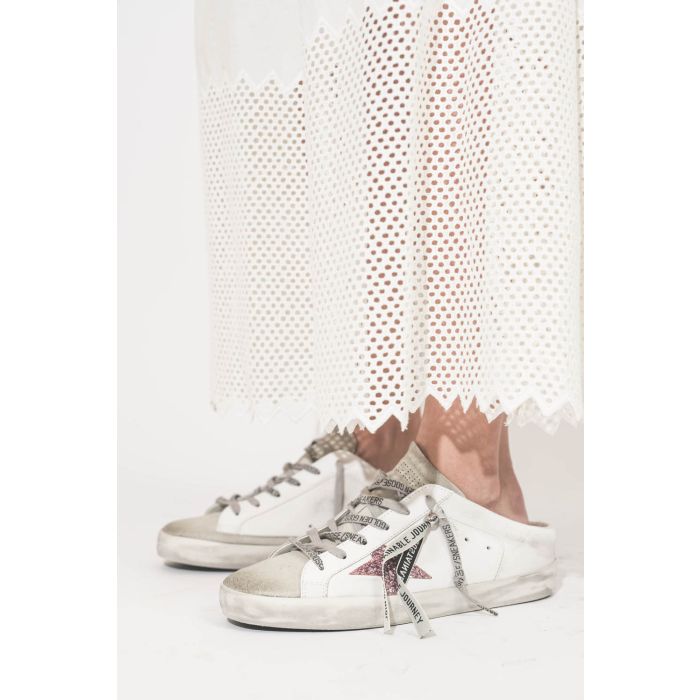 Sneakers Super Star sabot en cuir blanc étoile paillettes rose Golden Goose. Portées avec une jupe longue en coton et nid d'abeille blanc Canary The Great.