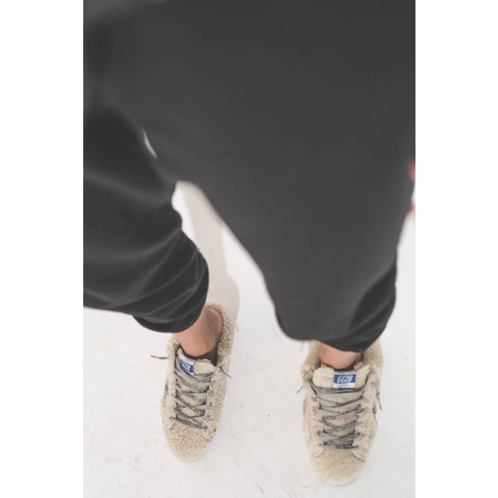 Sneakers sabot en fourrure de mouton retournée écru étoile à paillettes argentées 10757 Super-Star Sabot Golden Goose femme. Portées avec un bas de jogging Cropped noir The Great.