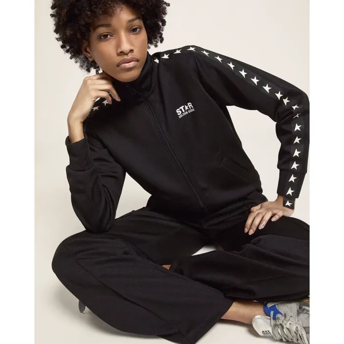 Veste de jogging noire avec étoiles blanches le long des manches Golden Goose. Porté de face.
