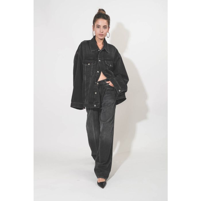Blouson oversized en jean noir délavé en Lyocell fluide Janet Haikure. Porté avec des créole en métal argenté.