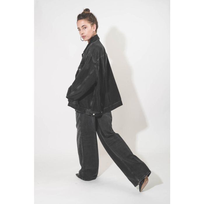 Blouson oversized en jean noir délavé en Lyocell fluide Janet Haikure. Porté profil dos.