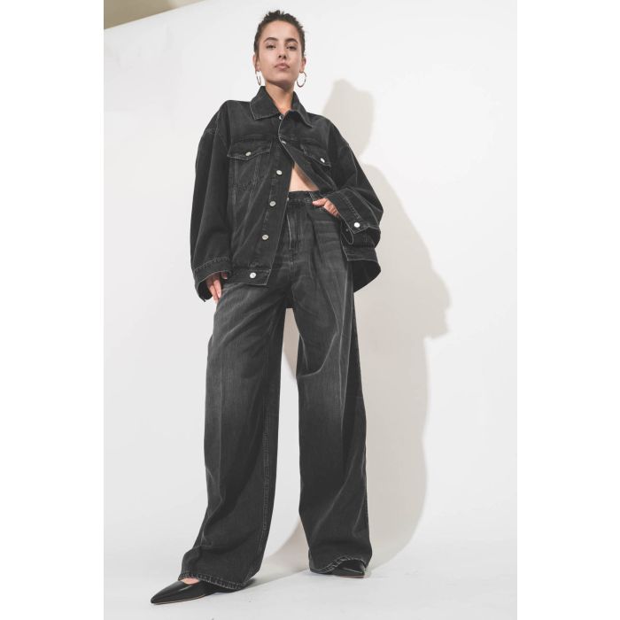 Blouson oversized en jean noir délavé en Lyocell fluide Janet Haikure. Porté en total look denim noir.