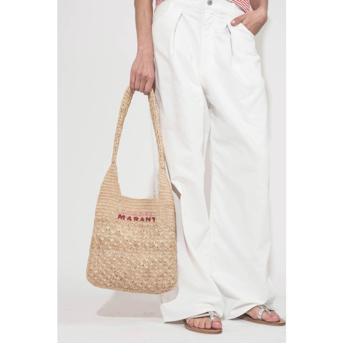 Jean large à pinces taille basse en toile blanche Candy Twill Haikure. Porté de face avec un panier en osier Isabel Marant et des sandales en cuir argent K.Jacques St-Tropez. Détail des pinces.