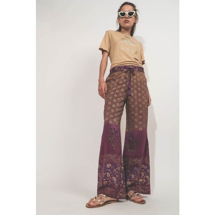 Pantalon fluide en soie imprimée Paul Hand.So.On. Pièce unique réalisée dans un sari vintage. Porté avec des sandales en cuir dorées.
