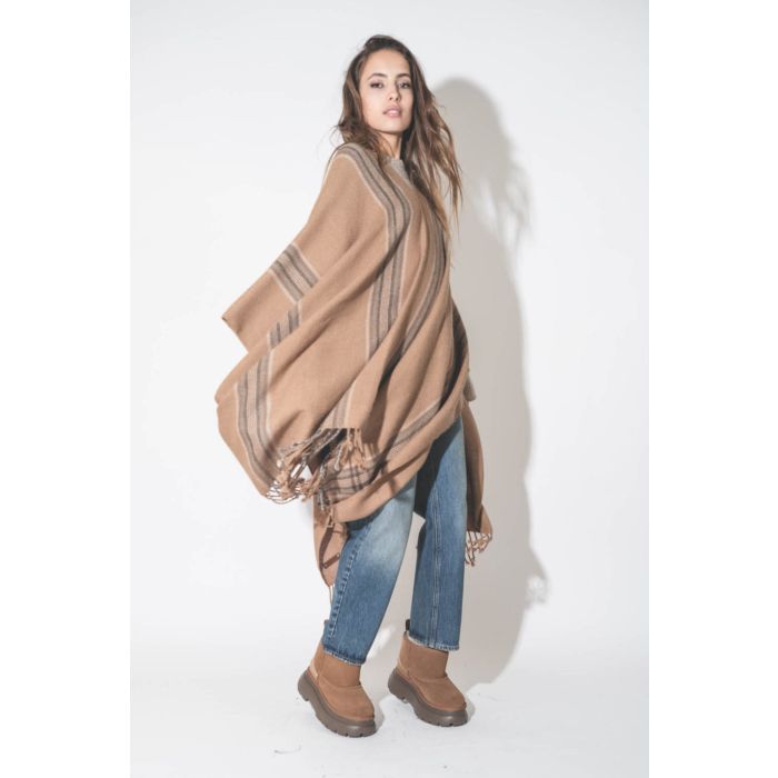 Poncho péruvien en alpaga à rayures camel Hand.So.On. Porté sur un jean boyfriend bleu.