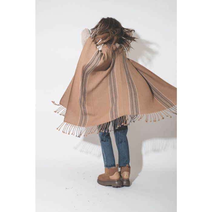 Poncho péruvien en alpaga à rayures camel Hand.So.On. Porté avec des boots fourrées en peau de mouton retournée.