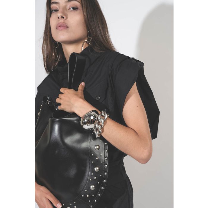 Bracelet manchette Awa Isabel Marant et bracelet gourmette Links Isabel Marant  en métal argenté. Porté avec un sac en cuir noir clouté.