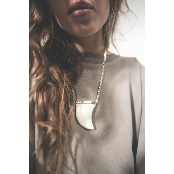 Collier oversize dent de requin en os écru sur chaine argent Ellen Isabel Marant. Porté sur un sweat-shirt kaki.