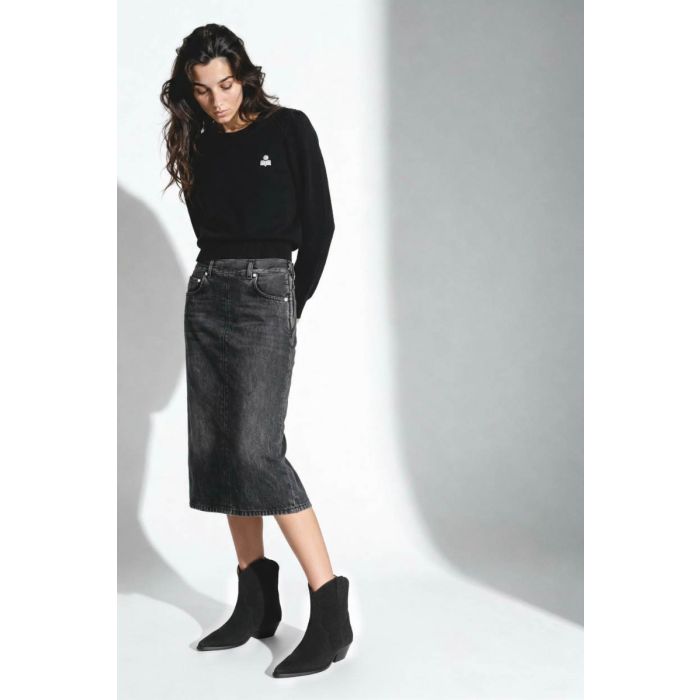 Pull Abelle Isabel Marant Étoile en coton et laine noir, logo brodé en argent sur la poitrine. Porté de face avec une jupe et des santiags noires.