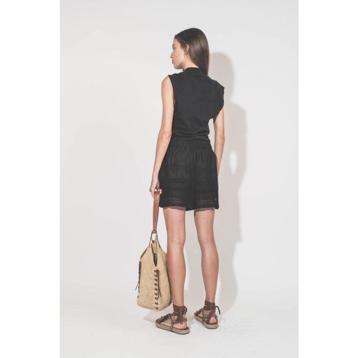 Short en voile de coton et dentelle noir Damina Marant Etoile. Porté de dos avec un tee-shirt noué noir Nayda Marant Etoile. Sandales Gypsa beige et panier en osier naturel finition en cuir cognac Tampa Isabel Marant. 
