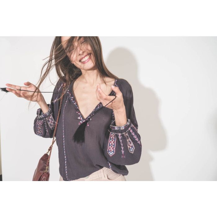 Top manches longues en voile de coton brodé bleu nuit lilas Fernanda Isabel Marant Etoile. Porté avec un jean large à pinces en coton rose poudré Candy Twill 45 Haikure. Sac Bobi S en cuir acajou Jérôme Dreyfuss. 
