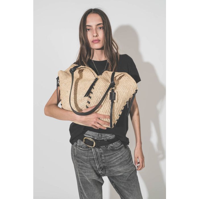 Panier en osier naturel finition cuir noir porté main ou épaule grand modèle Tampa Isabel Marant. Porté dans les bras avec un tee-shirt noir Boxy Crew The Great et un jean Crossover Leyton Black R13 Denim. Ceinture Dara Isabel Marant.