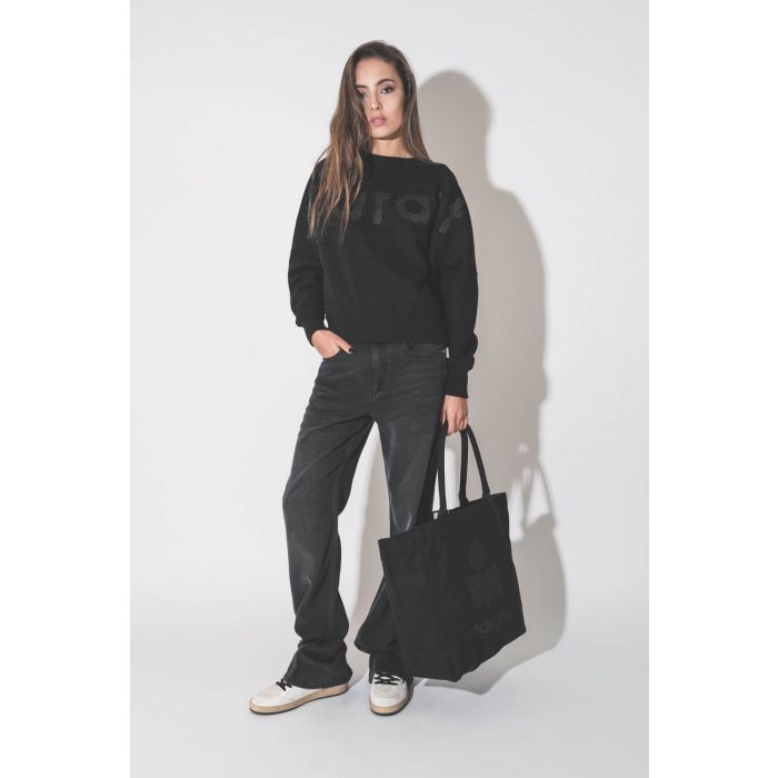 Grand cabas en toile noir logo MARANT à paillettes noires Yenky Isabel Marant. Porté de profil.