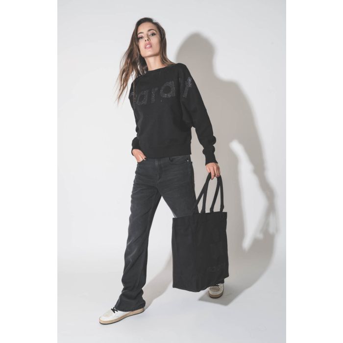 Grand cabas en toile noir logo MARANT à paillettes noires Yenky Isabel Marant. Porté en total look noir.
