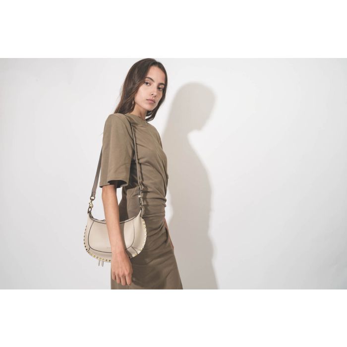 Mini sac en cuir grainé écru clouté finition métal doré Oskan Moon Isabel Marant. Porté de face. 