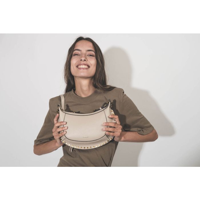 Mini sac en cuir grainé écru clouté finition métal doré Oskan Moon Isabel Marant. Porté main. 