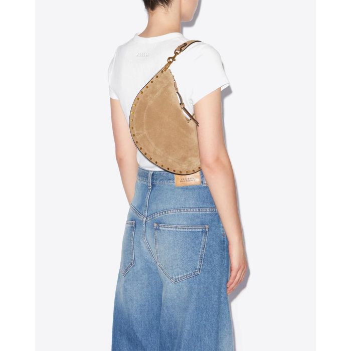 Sac Oskan Soft Zip Isabel Marant en cuir suédé taupe et clouté. Bandoulière courte pour un porté main ou épaule et une bandoulière longue pour un porté épaule ou croisé. Porté épaule avec la anse courte.