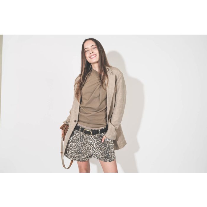 Tee-shirt sans manches noué sur le côté en jersey kaki clair Nayda Marant Etoile. Porté sous un blazer oversized en lin beige Ragged R13 et un short en coton écru léopard Pocket R13. Ceinture Dara noire Isabel Marant. Pochette en cuir suédé caramel Lucky 