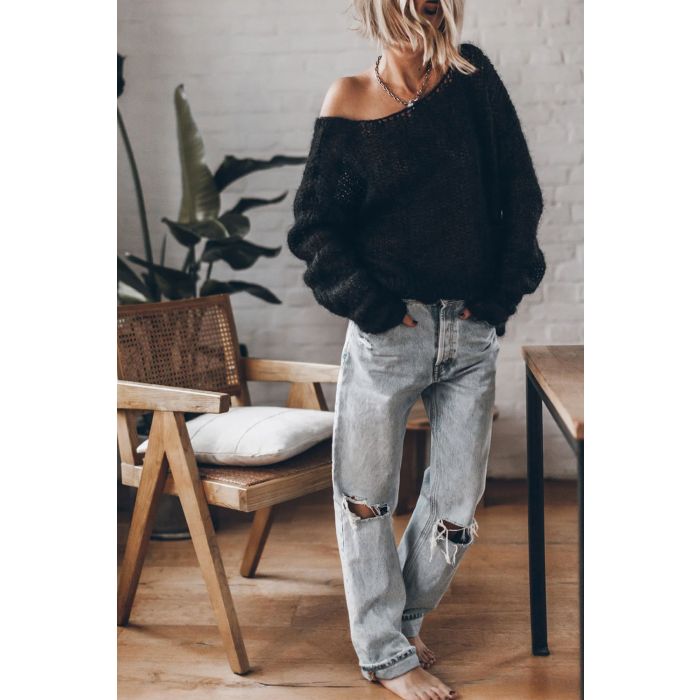 Jean boyfriend en denim bleu ciel déchiré Mikuta. Porté de face avec un pull en mohair dos nu.