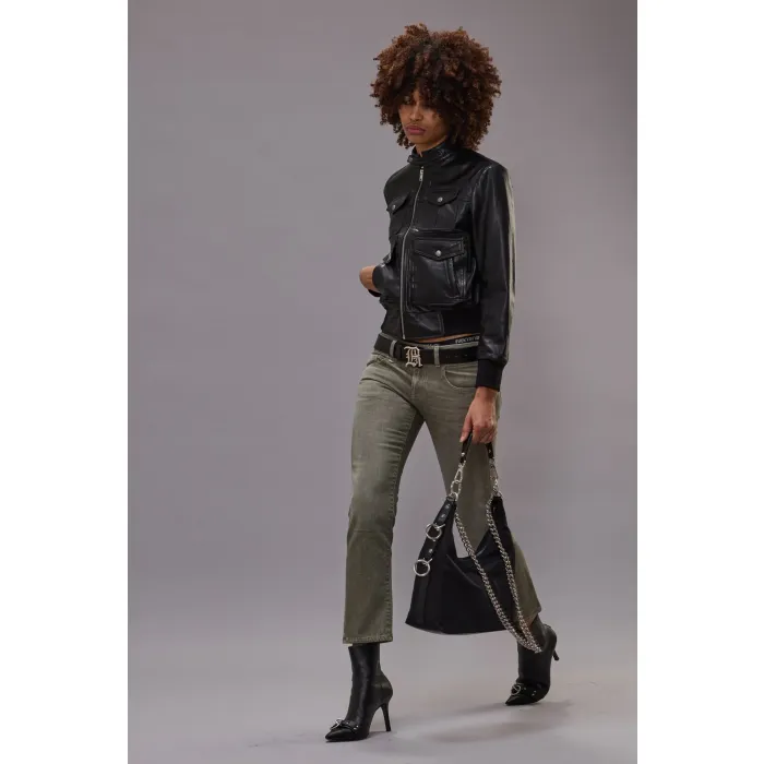 Jean taille basse Boy Straight Army Green Stretch kaki R13 denim. Porté avec un blouson en cuir noir.